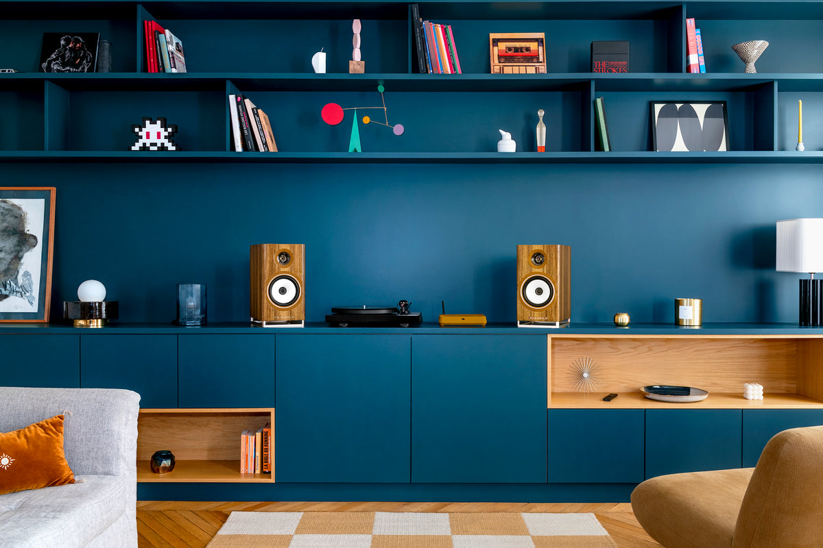 Enceintes blanches et platine vinyle sur un meuble bleu